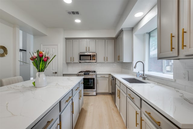 kitchen featuring visible vents, recessed lighting, gray cabinets, a sink, and stainless steel appliances
