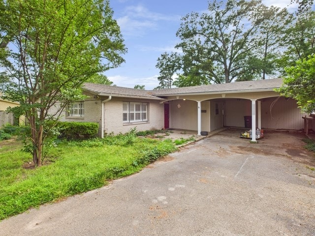 single story home featuring driveway and an attached carport
