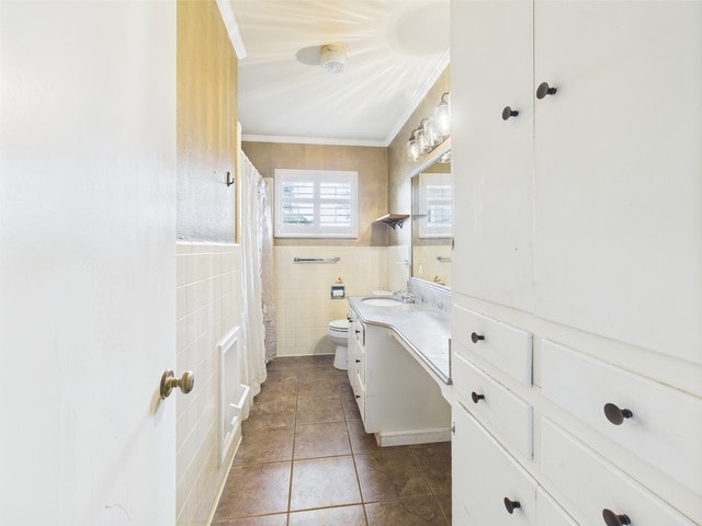full bathroom featuring tile patterned flooring, vanity, toilet, tile walls, and ornamental molding