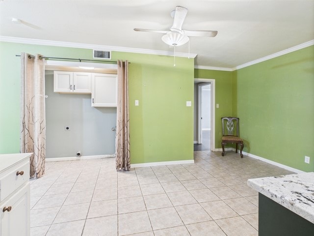 interior space featuring light tile patterned flooring, ceiling fan, white cabinetry, visible vents, and ornamental molding