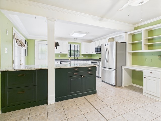 kitchen with appliances with stainless steel finishes, white cabinetry, ornamental molding, green cabinetry, and light tile patterned flooring