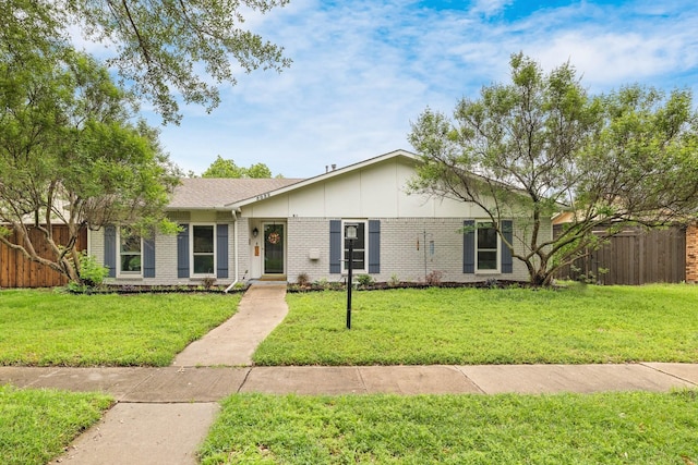 ranch-style house featuring brick siding, fence, and a front lawn