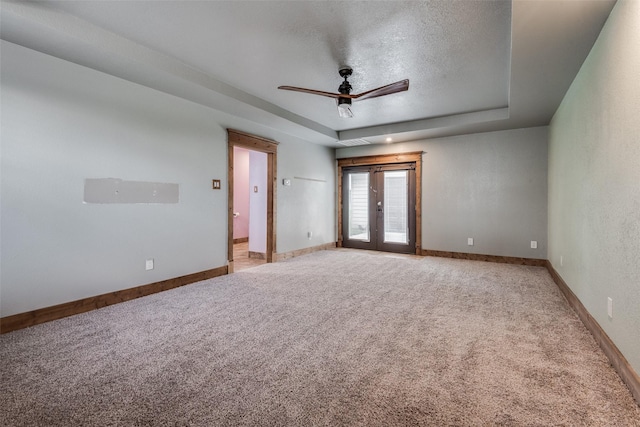 5313 Old Buena Vista Rd, Waxahachie, TX 75167 - spare room with a ceiling fan, a textured ceiling, a raised ceiling, baseboards, and light carpet