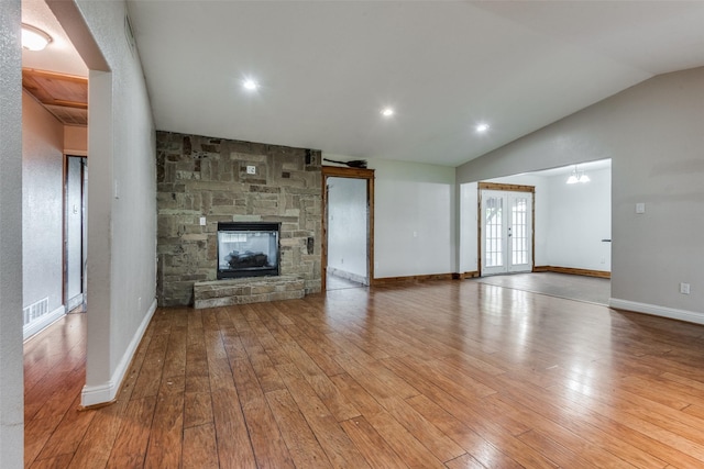 5313 Old Buena Vista Rd, Waxahachie, TX 75167 - unfurnished living room featuring hardwood / wood-style flooring, a stone fireplace, french doors, and lofted ceiling
