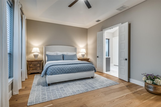 bedroom featuring a ceiling fan, visible vents, and light wood-type flooring