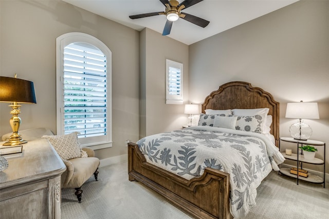 bedroom with a ceiling fan, baseboards, multiple windows, and carpet