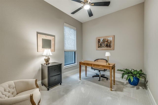 office featuring baseboards, ceiling fan, and light carpet