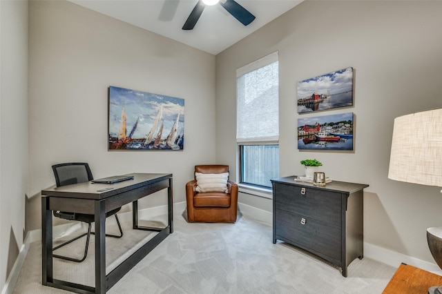 office space with baseboards, light colored carpet, and ceiling fan