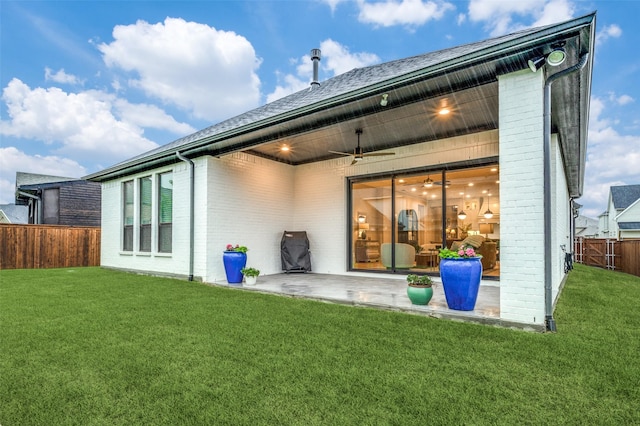 back of property featuring a lawn, brick siding, a patio, and a fenced backyard