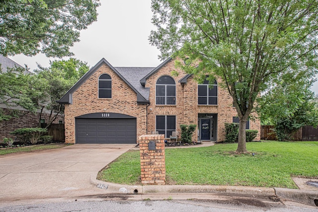 traditional-style house featuring driveway, brick siding, fence, a front lawn, and an attached garage