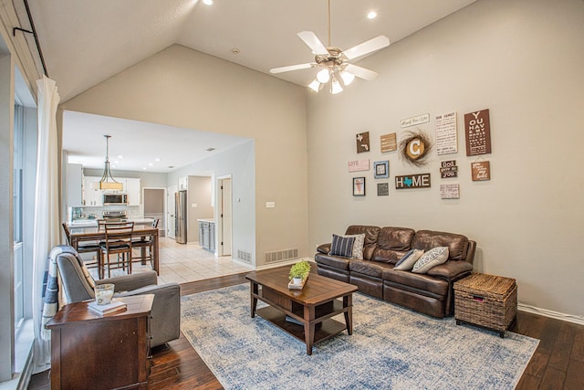 living room featuring visible vents, baseboards, recessed lighting, a ceiling fan, and light wood finished floors