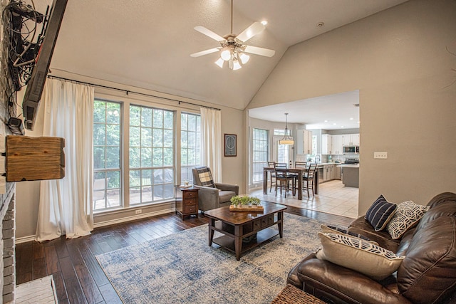 living area with high vaulted ceiling, ceiling fan, and hardwood / wood-style flooring