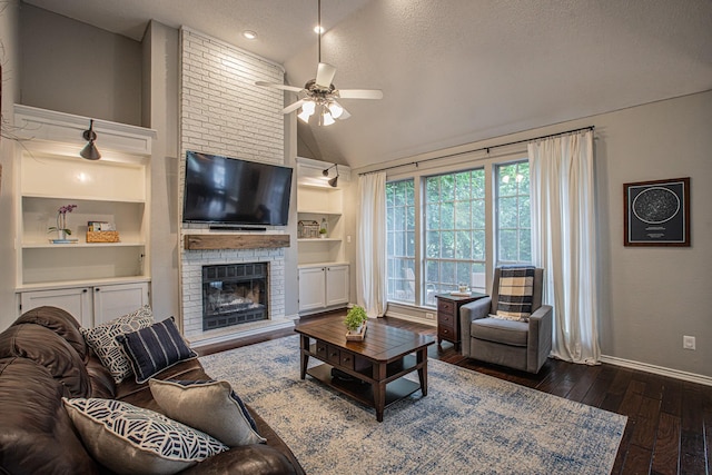 living area featuring ceiling fan, a textured ceiling, dark wood finished floors, built in shelves, and baseboards