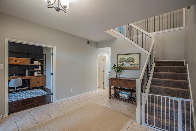 entrance foyer featuring visible vents, tile patterned flooring, baseboards, a chandelier, and stairs