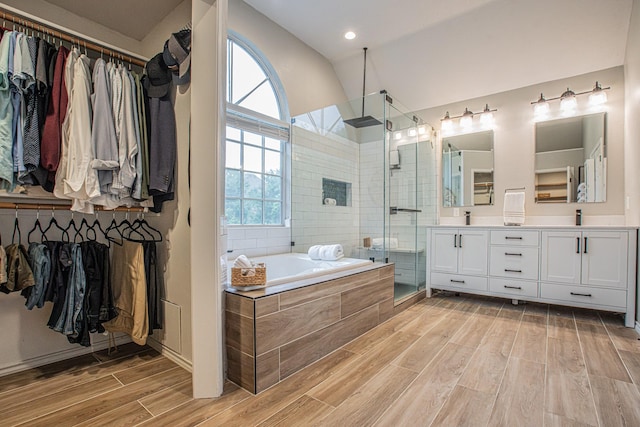 full bathroom with a garden tub, plenty of natural light, a stall shower, and wood finished floors