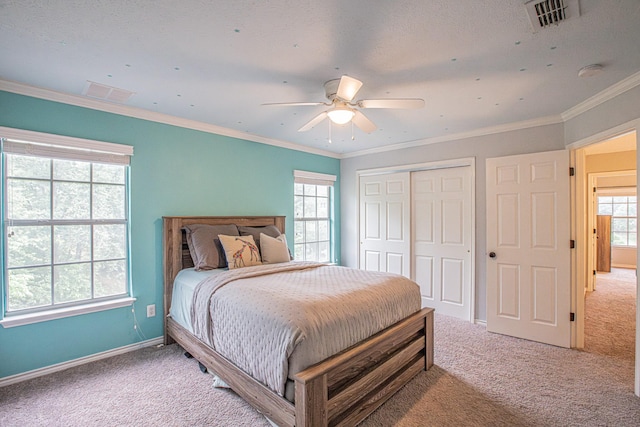 bedroom with baseboards, visible vents, light carpet, and a closet