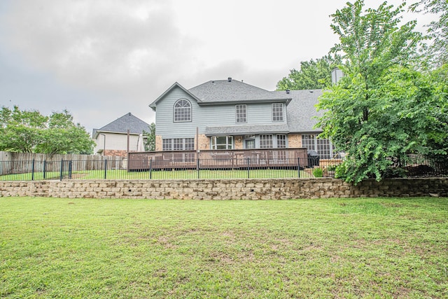 rear view of property featuring brick siding, a fenced backyard, a wooden deck, and a yard