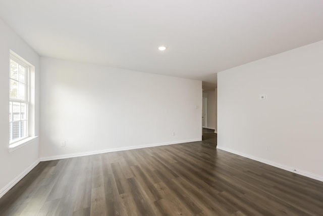 unfurnished room with baseboards, recessed lighting, and dark wood-style flooring