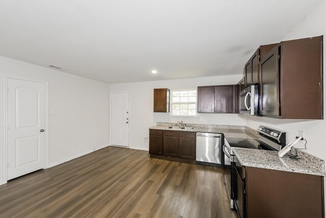 kitchen with dark wood-style flooring, dark brown cabinets, appliances with stainless steel finishes, a sink, and visible vents