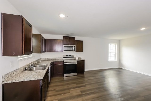 kitchen with light countertops, a sink, dark brown cabinets, and stainless steel appliances