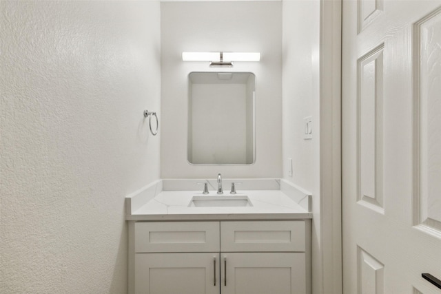 bathroom featuring vanity and a textured wall