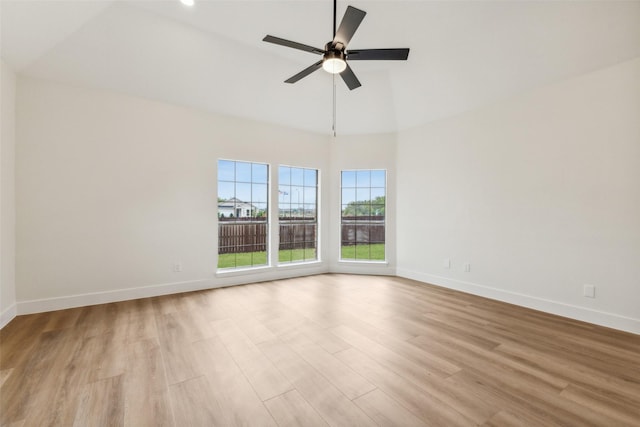 spare room featuring baseboards, ceiling fan, wood finished floors, and high vaulted ceiling