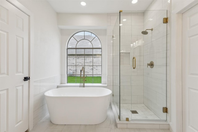 bathroom featuring a freestanding tub, tile walls, a stall shower, tile patterned floors, and recessed lighting