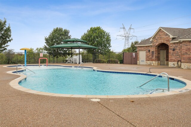 pool with fence, a gazebo, and a patio area