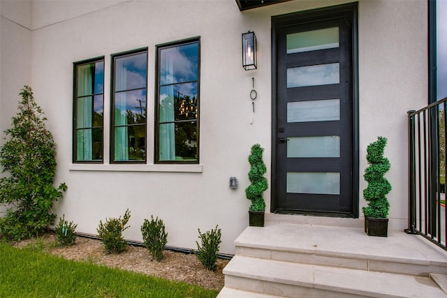 doorway to property featuring stucco siding