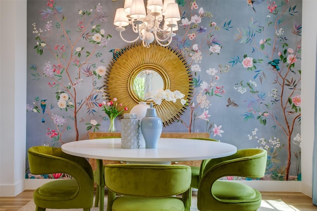 dining area with baseboards, an inviting chandelier, and wood finished floors