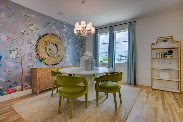 dining room featuring baseboards, wood finished floors, a notable chandelier, and wallpapered walls