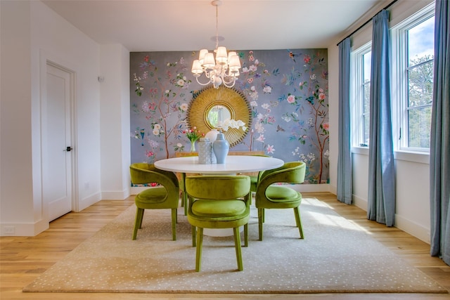 dining area featuring baseboards, an inviting chandelier, wallpapered walls, and wood finished floors