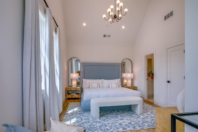 bedroom with high vaulted ceiling, visible vents, an inviting chandelier, and light wood-style floors