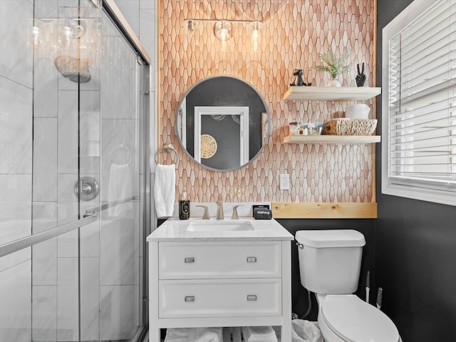 bathroom featuring vanity, a stall shower, and toilet