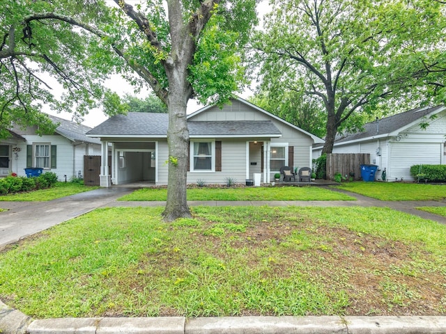 view of front of home with a front lawn, fence, driveway, and a carport