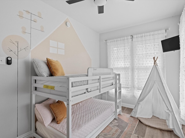 bedroom with baseboards, a ceiling fan, and wood finished floors