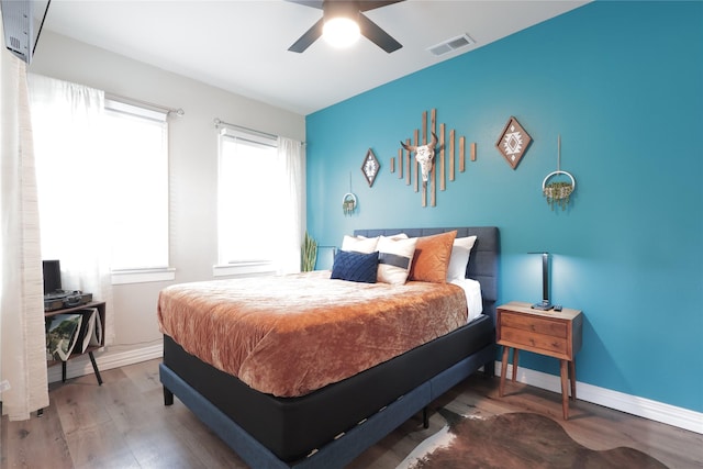 bedroom with visible vents, baseboards, ceiling fan, and wood finished floors