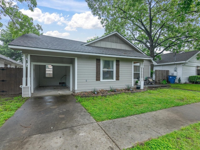 view of front of property featuring a front lawn, fence, a shingled roof, board and batten siding, and driveway