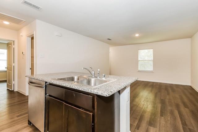kitchen with stainless steel dishwasher, visible vents, dark brown cabinets, a center island with sink, and a sink