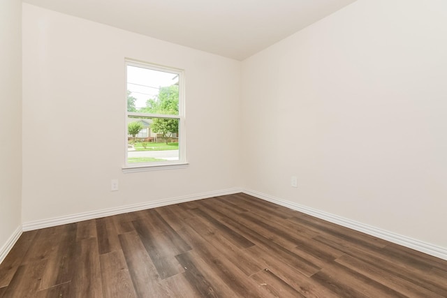 empty room with dark wood-style flooring and baseboards