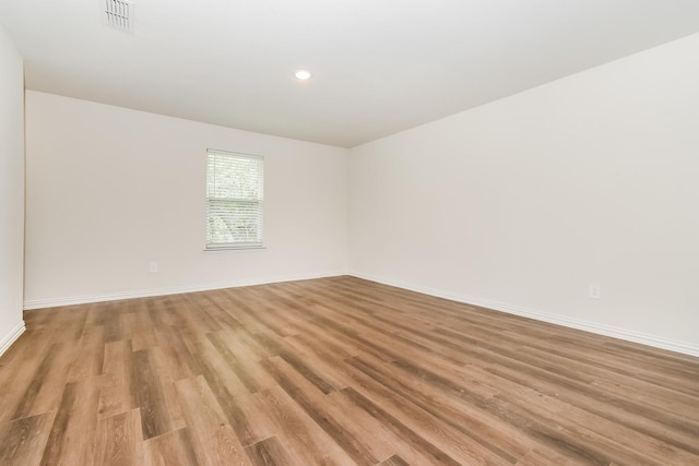 empty room with visible vents, recessed lighting, light wood finished floors, and baseboards
