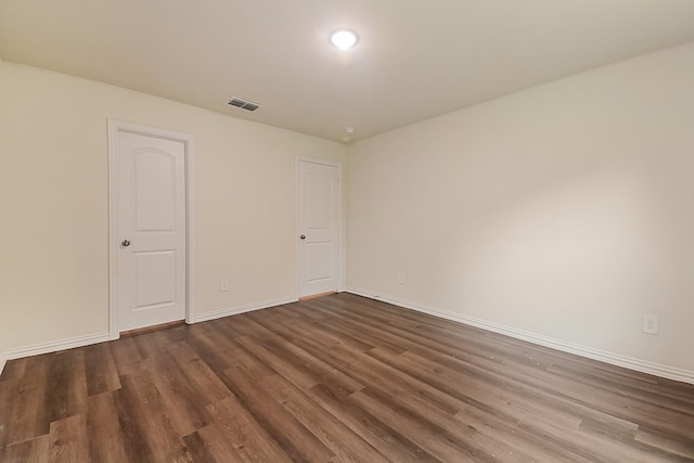 unfurnished room with visible vents, recessed lighting, baseboards, and dark wood-style floors