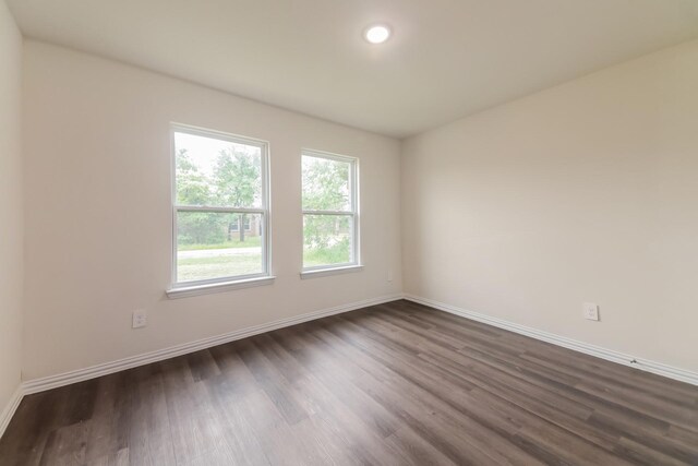 unfurnished room with baseboards, recessed lighting, and dark wood finished floors