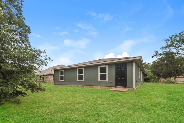 back of property with a lawn