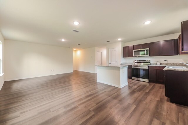 kitchen with a sink, stainless steel appliances, open floor plan, a kitchen island, and visible vents
