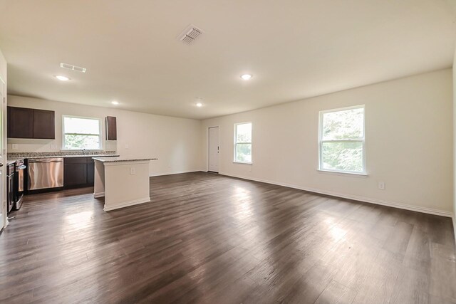 unfurnished living room with visible vents, dark wood finished floors, and plenty of natural light