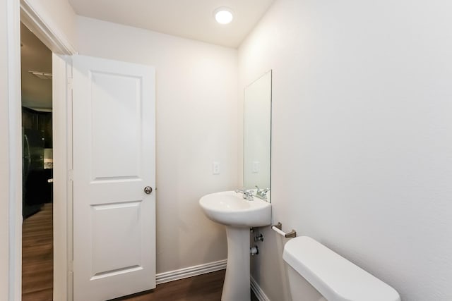 609 Sherman St, Waco, TX 76704 - half bath featuring toilet, baseboards, a sink, and wood finished floors