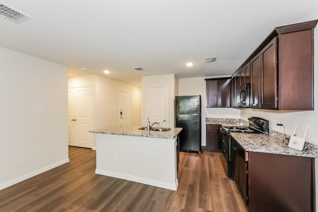 609 Sherman St, Waco, TX 76704 - kitchen featuring a sink, an island with sink, dark wood-type flooring, visible vents, and black appliances