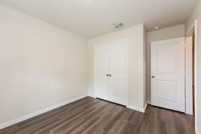 609 Sherman St, Waco, TX 76704 - unfurnished bedroom with a closet, baseboards, visible vents, and dark wood-type flooring