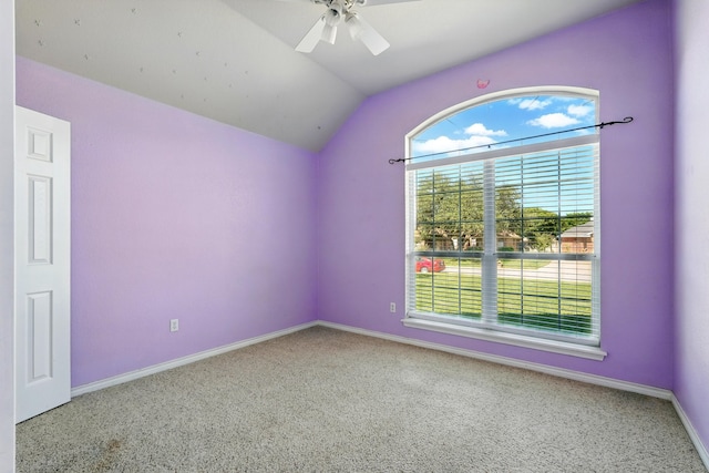 carpeted empty room featuring a ceiling fan, baseboards, vaulted ceiling, and a healthy amount of sunlight